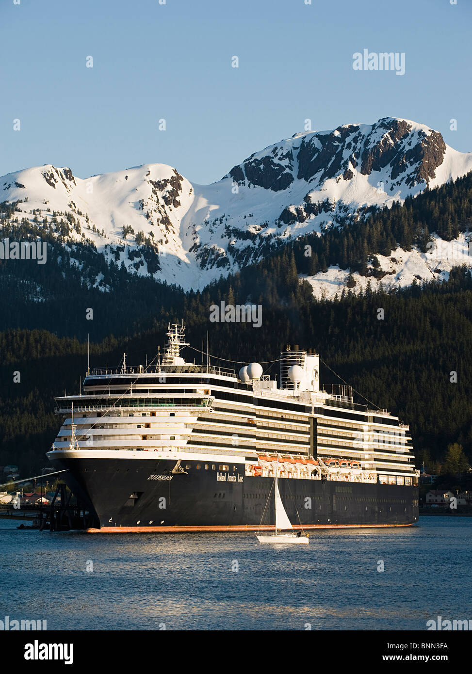 Ein Segelboot geht vor der angedockten Holland America Line Kreuzfahrt Schiff/n'Zuiderdam ' in Gastineau Channel, Juneau, Alaska Stockfoto