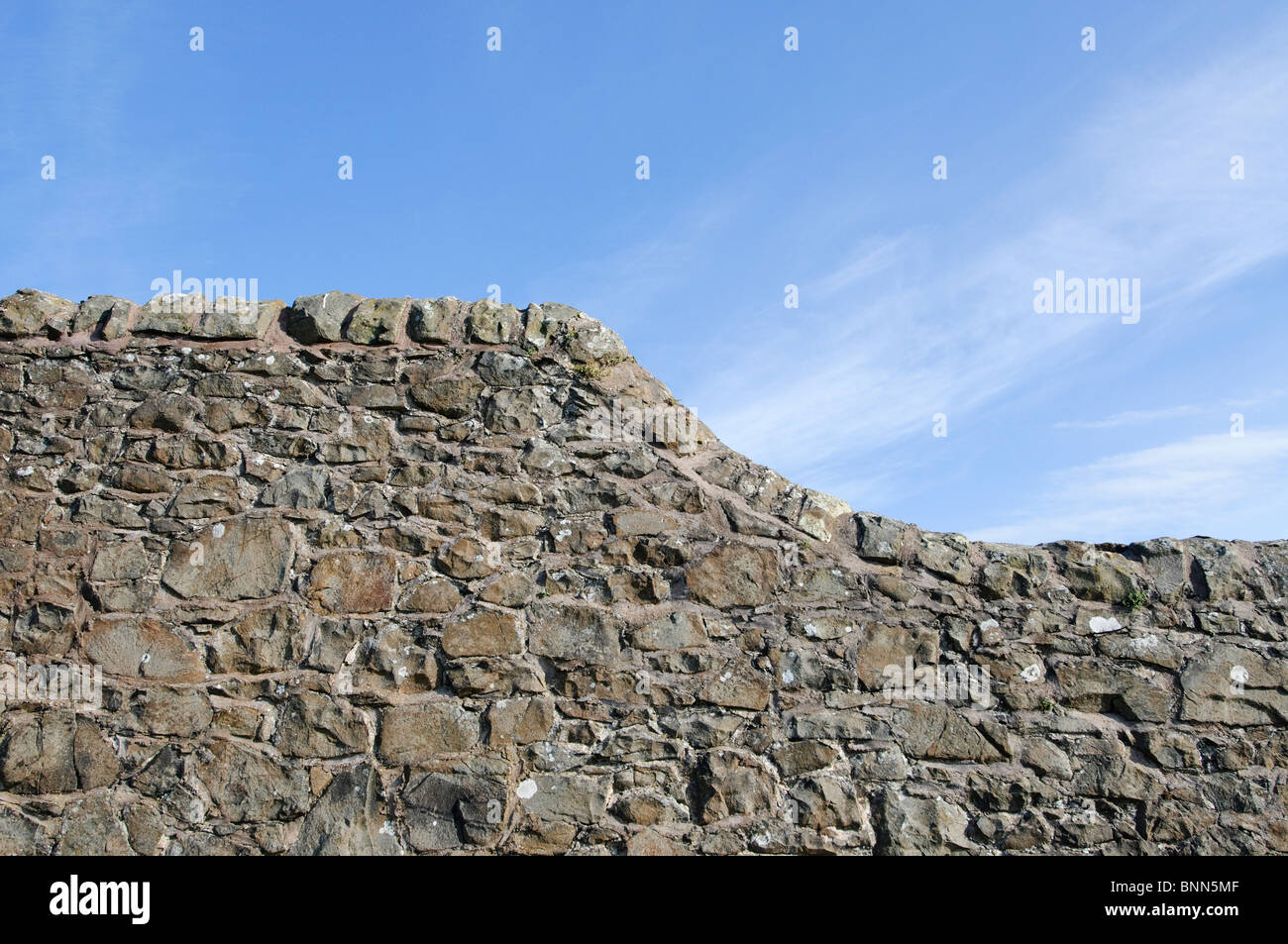 Steinmauer mit einer anmutigen Kurve, vor blauem Himmel. Stockfoto