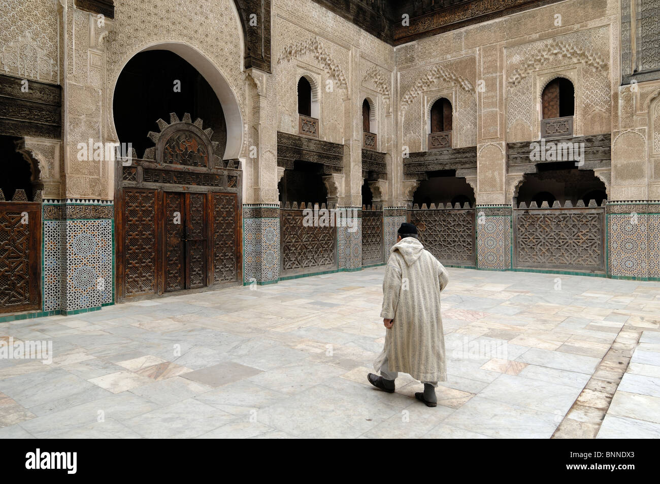 Marokkanischer Mann mit Jellaba oder ethnischer Kleidung in Bou Inania Medersa (1350-56) oder Medresse (Koranische Schule), Fez, Marokko Stockfoto