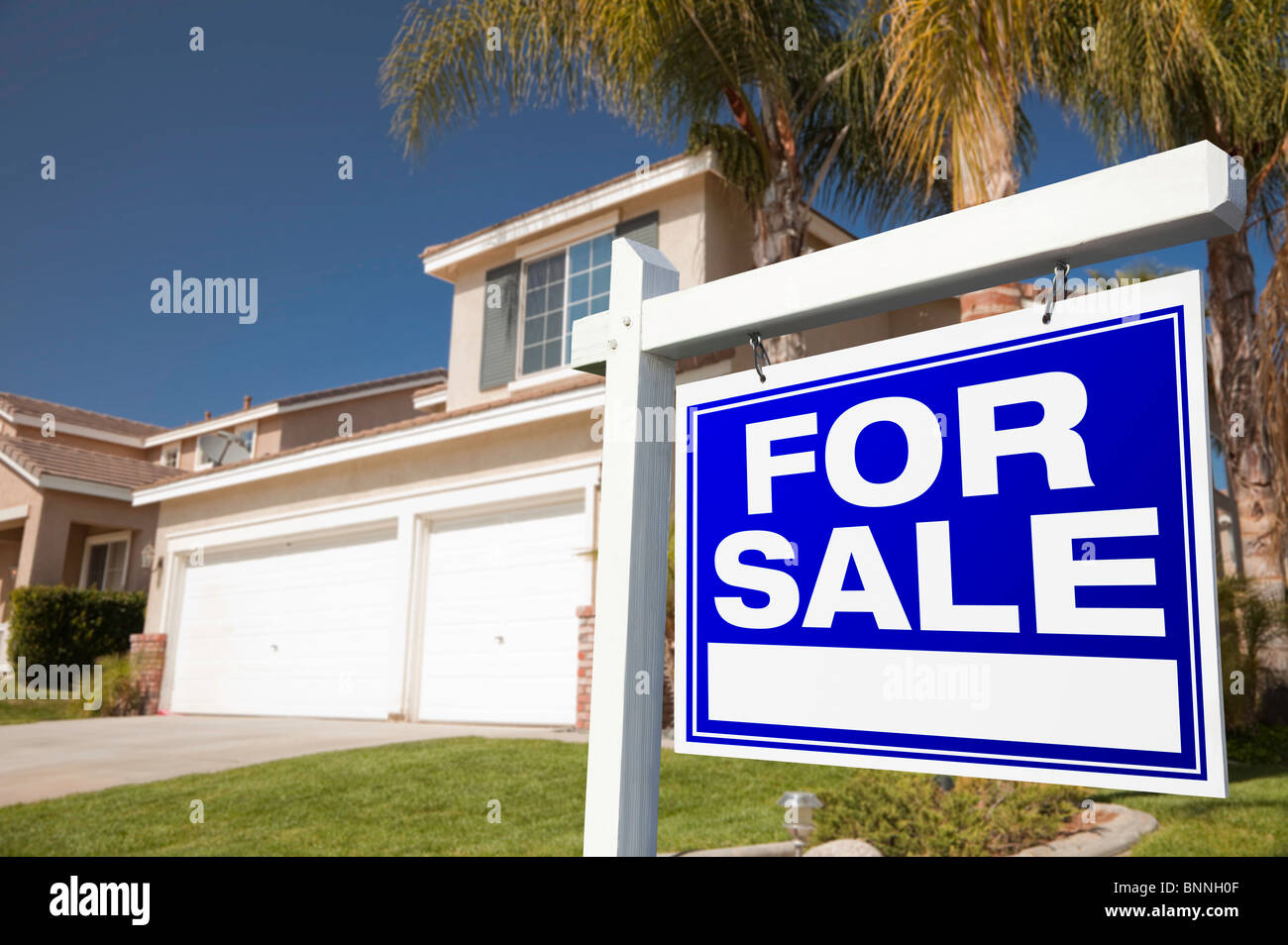 Blau für Verkauf Immobilien Zeichen vor Haus. Stockfoto