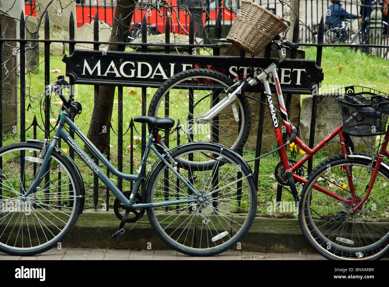Fahrräder sind auf Geländern in der Magdalen Street, Oxford, UK, eingesperrt Stockfoto