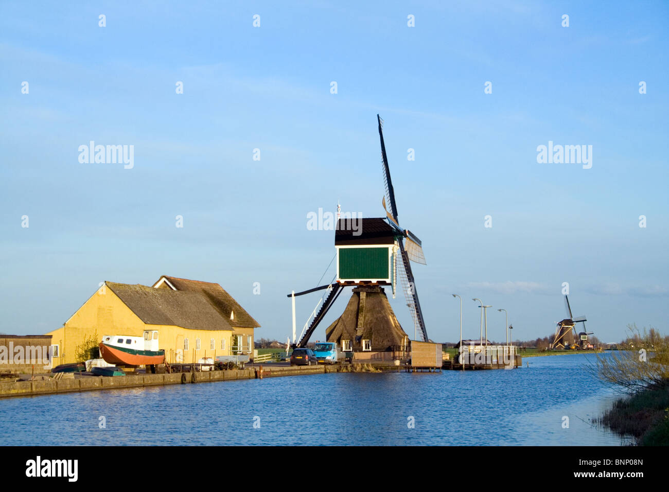 Neben einem Fluss in einem Polder in Holland Windmühle Stockfoto
