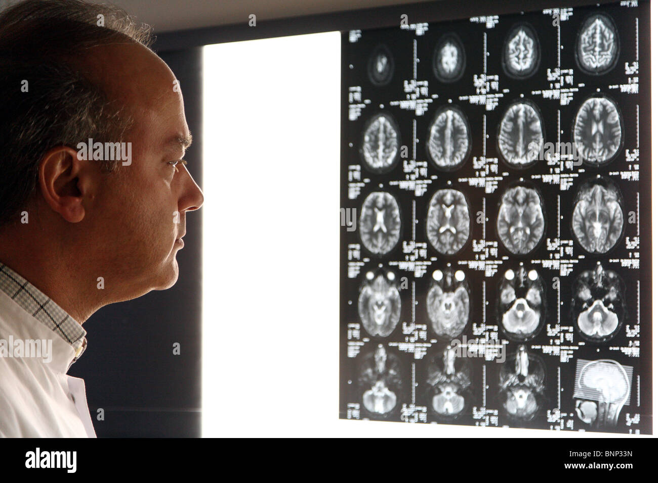 Thomas Muehlberger MD wirft einen Blick auf MRT-Aufnahmen des Kopfes Stockfoto