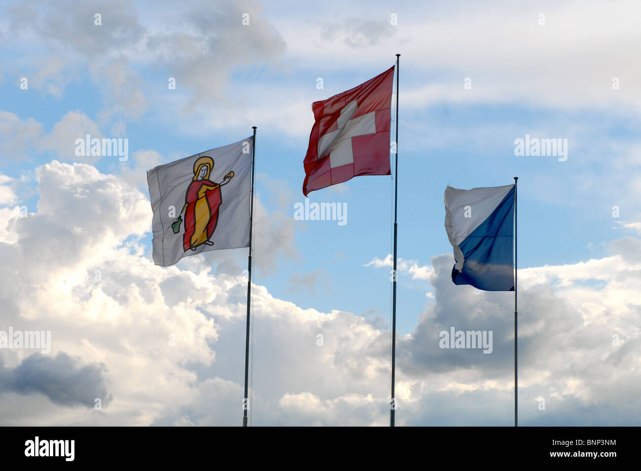 Drei Fahnen gegen blauen Himmel und Wolken Stockfoto