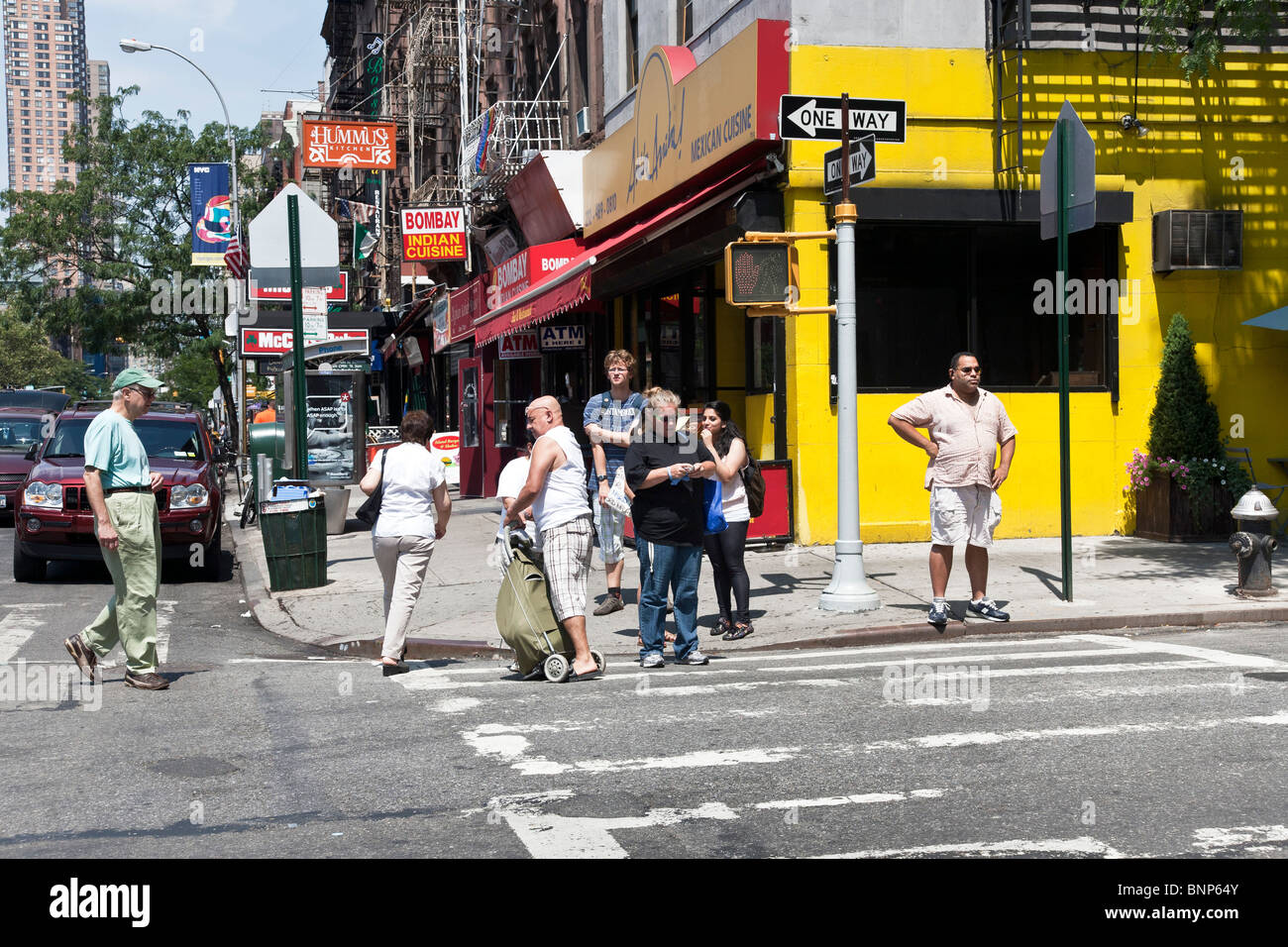 bunt gemischte Gruppe von Fußgängern gehen in verschiedene Richtungen versammeln sich am Ecke von West Side Manhattan block Stockfoto