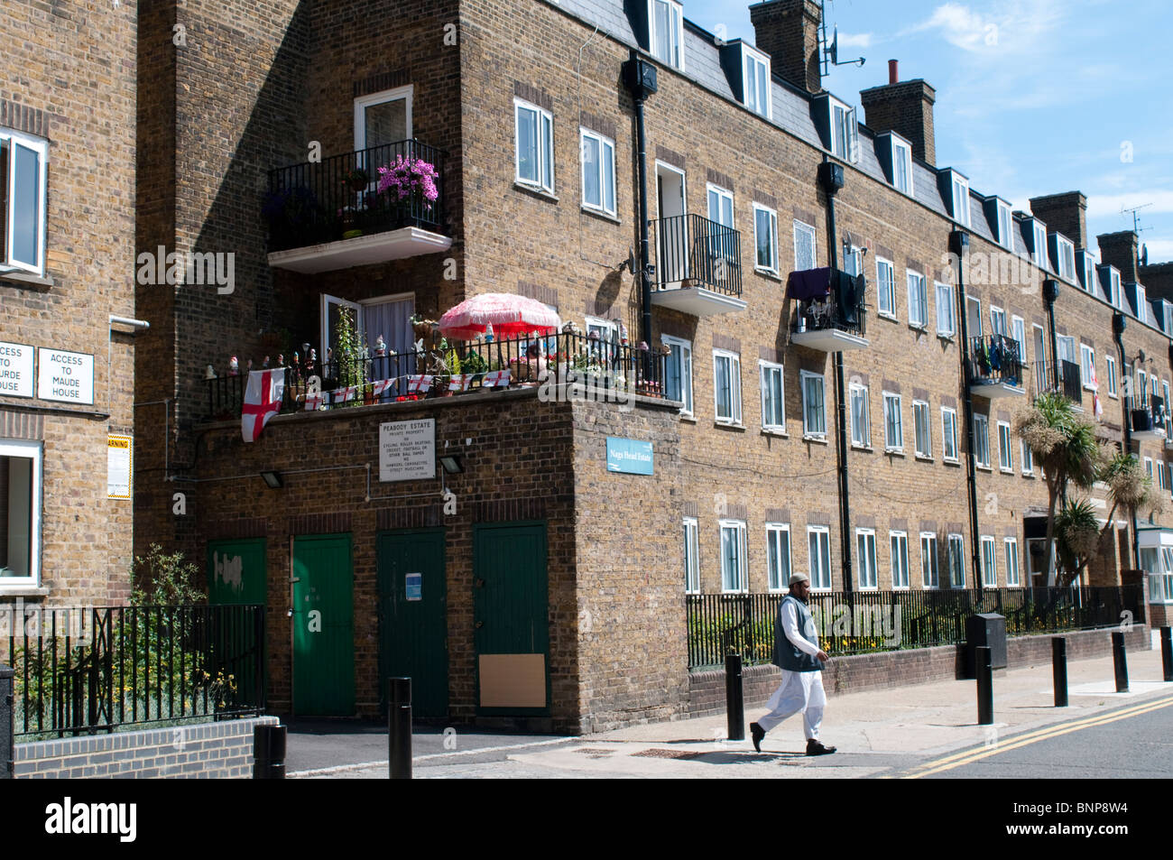 Muslimischen Mann zu Fuß vor der Peabody Estate, London, E2, England, UK Stockfoto