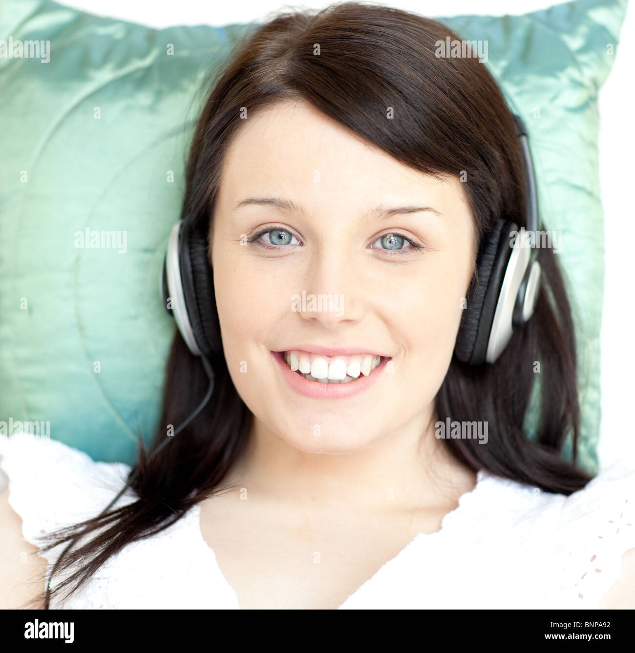 Junge Frau auf einem Sofa liegend Musik hören Stockfoto