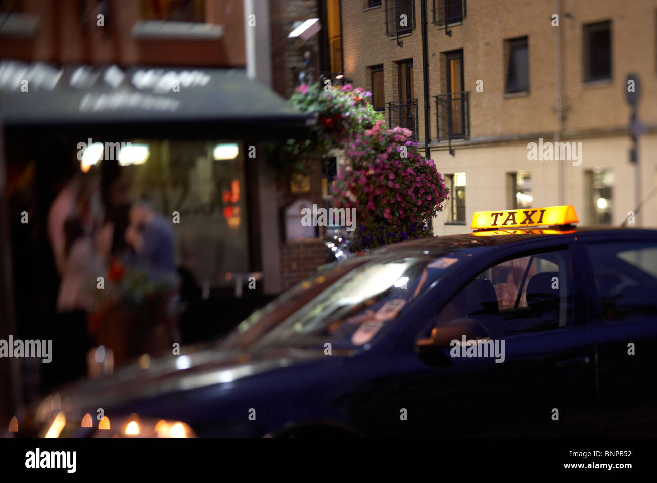 Taxi wartet vor Pub in der Nacht im Stadtzentrum von Belfast Nordirland Vereinigtes Königreich. Stockfoto