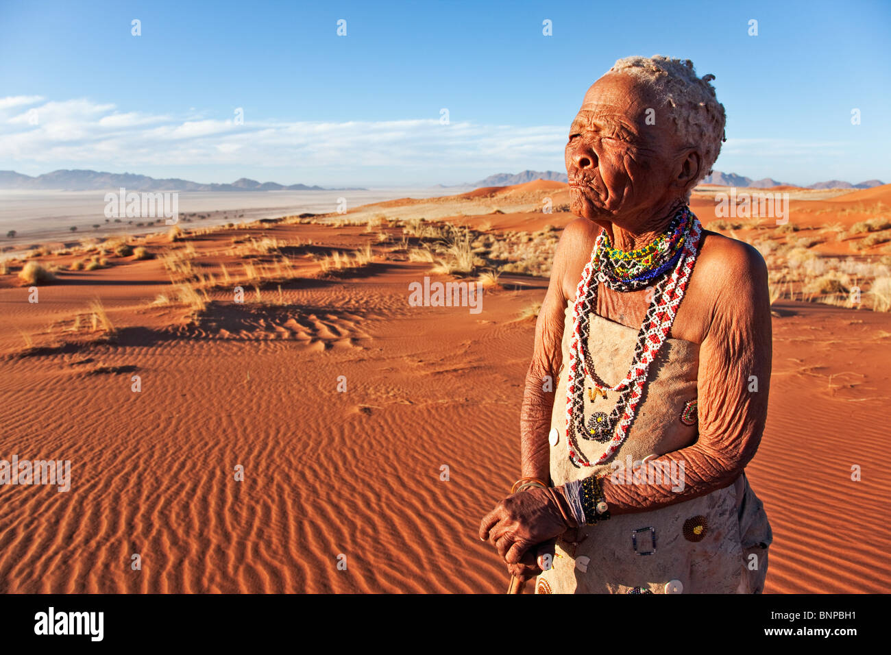 Ältere Buschmann / San Frau stehend in Wüste Stockfoto