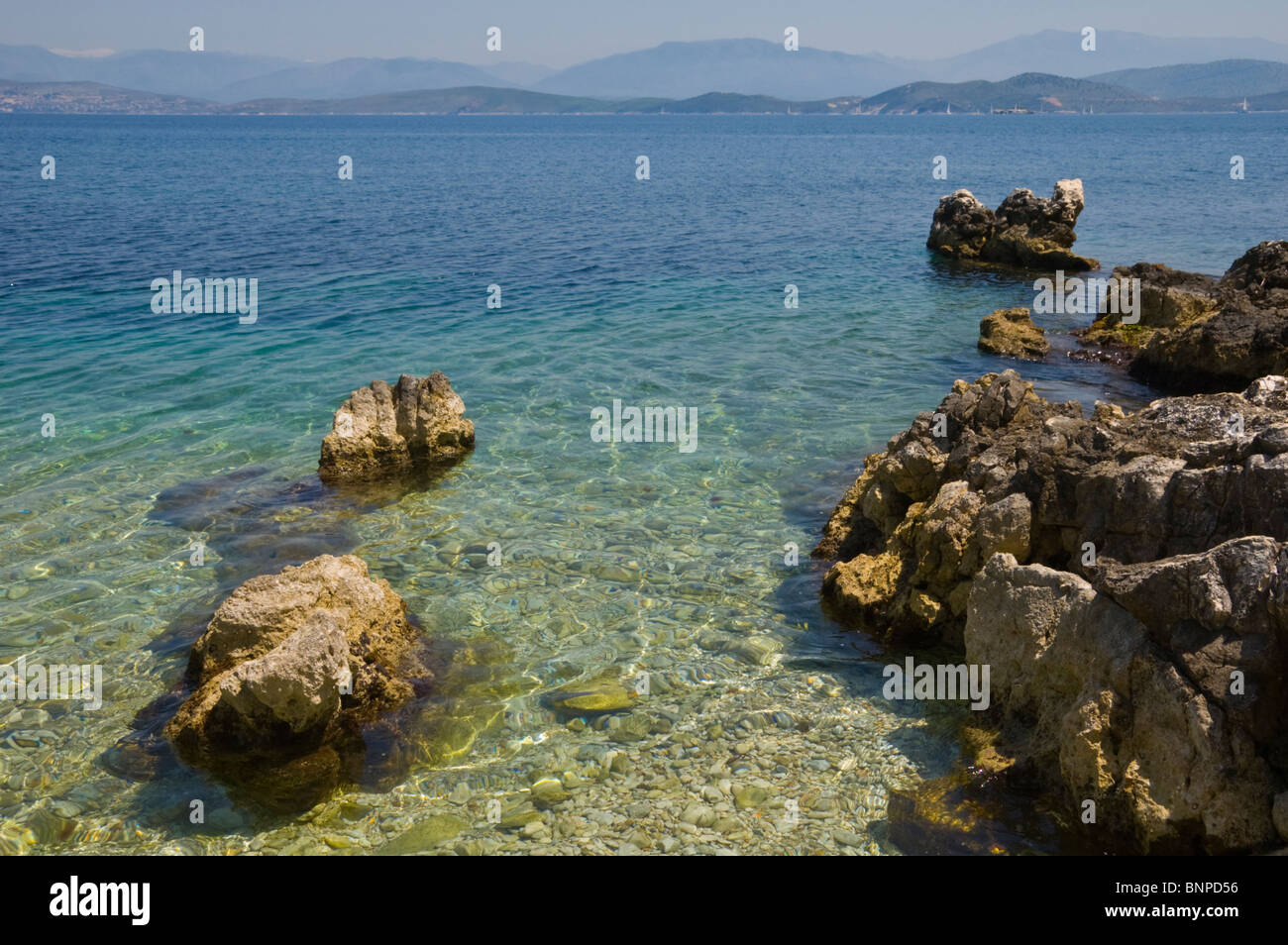 Felsküste bei Kassiopi auf der griechischen Mittelmeer Insel Korfu Griechenland GR Bergen Albaniens am Horizont Stockfoto