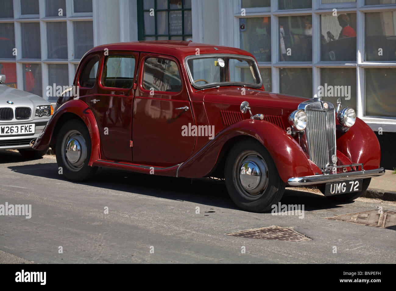 Alte 1949 MG YA MG Y-Type-Limousine, die neben dem modernen BMW in Cerne Abbas, Dorset UK, auf der Straße geparkt ist Stockfoto