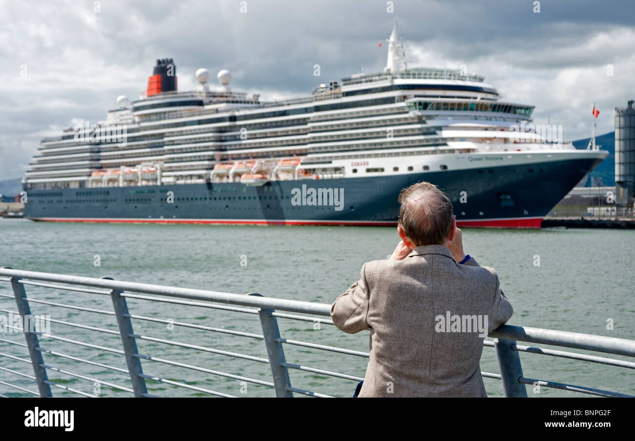 Ein Mann fotografiert Cunard-Liner, die Königin Victoria in Belfast vor Anker Stockfoto