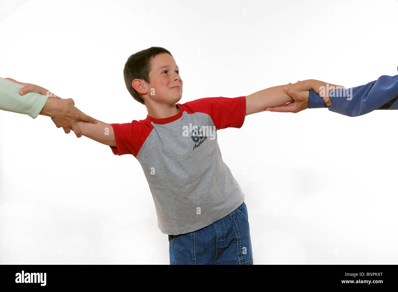 Ein gestellten Bild der Darstellung des Kindes hin und her gerissen zwischen beiden Eltern in Konflikt. Stockfoto
