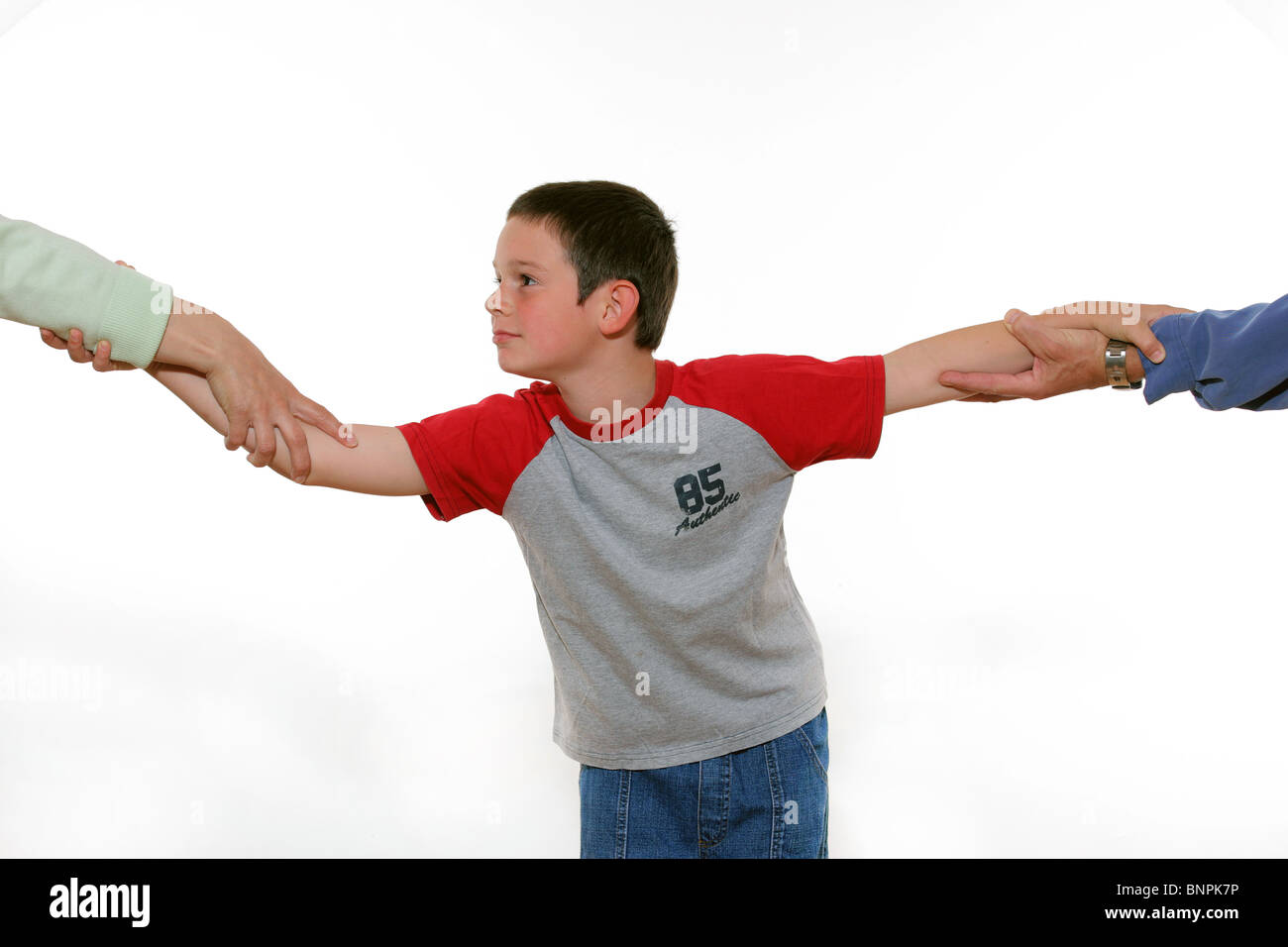 Ein gestellten Bild der Darstellung des Kindes hin und her gerissen zwischen beiden Eltern in Konflikt. Stockfoto
