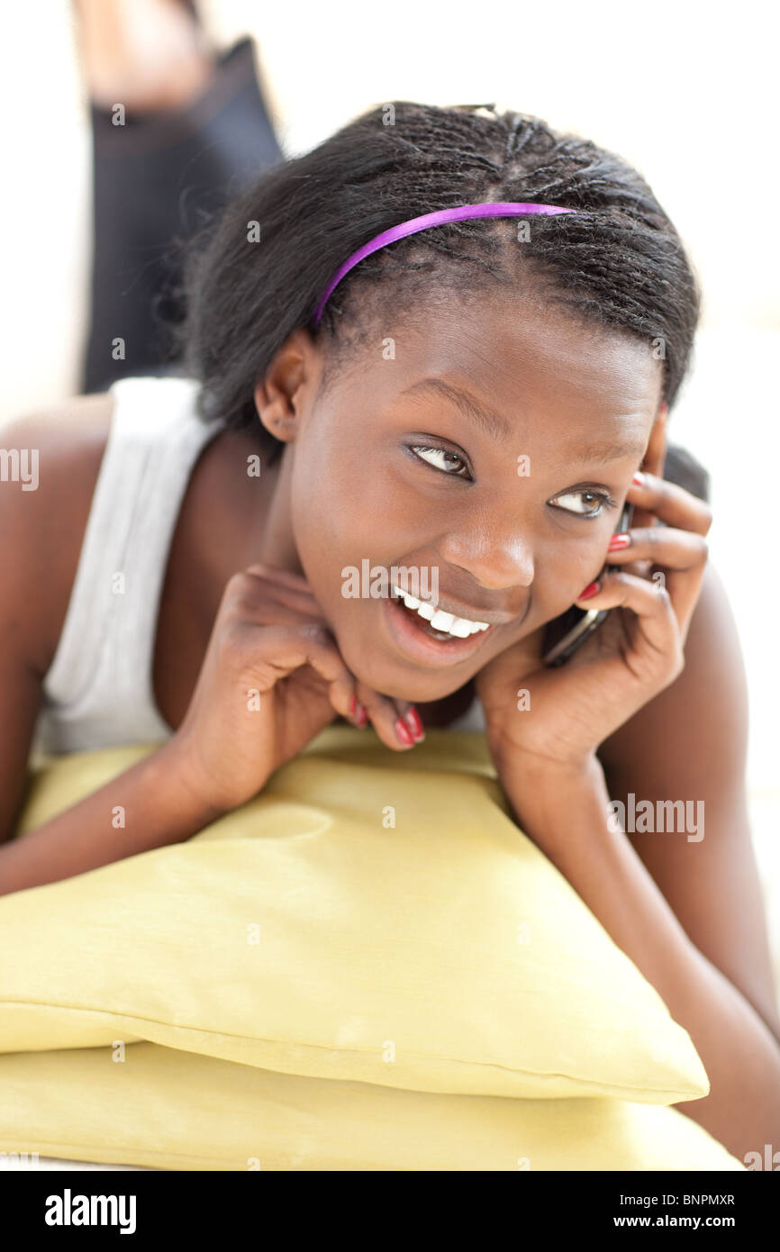 Stets gut gelaunte Frau am Telefon auf einem Sofa liegend Stockfoto