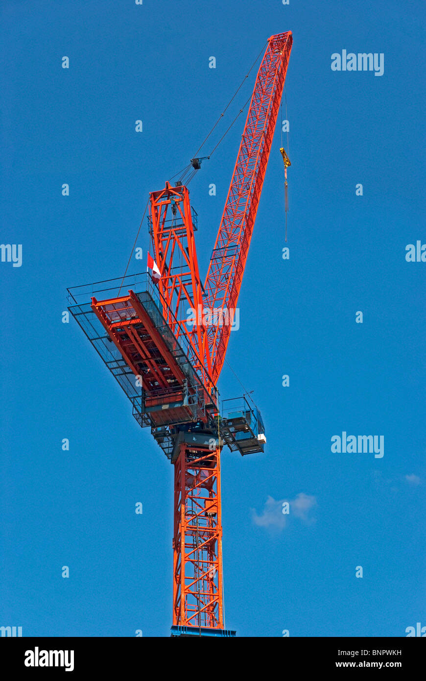 Roter Turmdrehkran gegen blauen Himmel - eine Nahaufnahme. Stockfoto