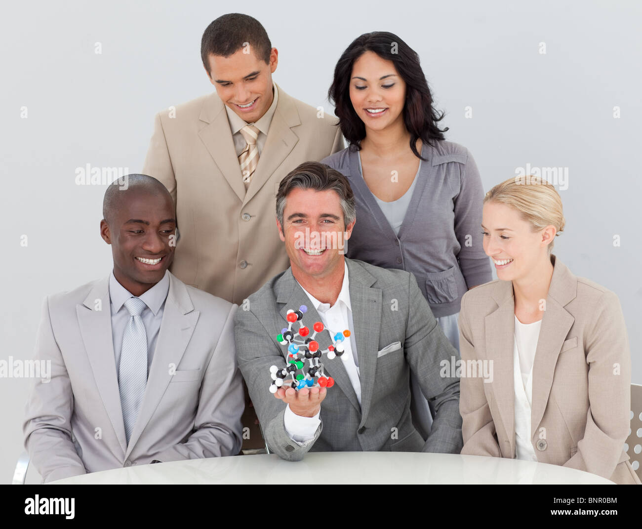 Lächelnde Musiness Team halten Moleküle im Büro Stockfoto