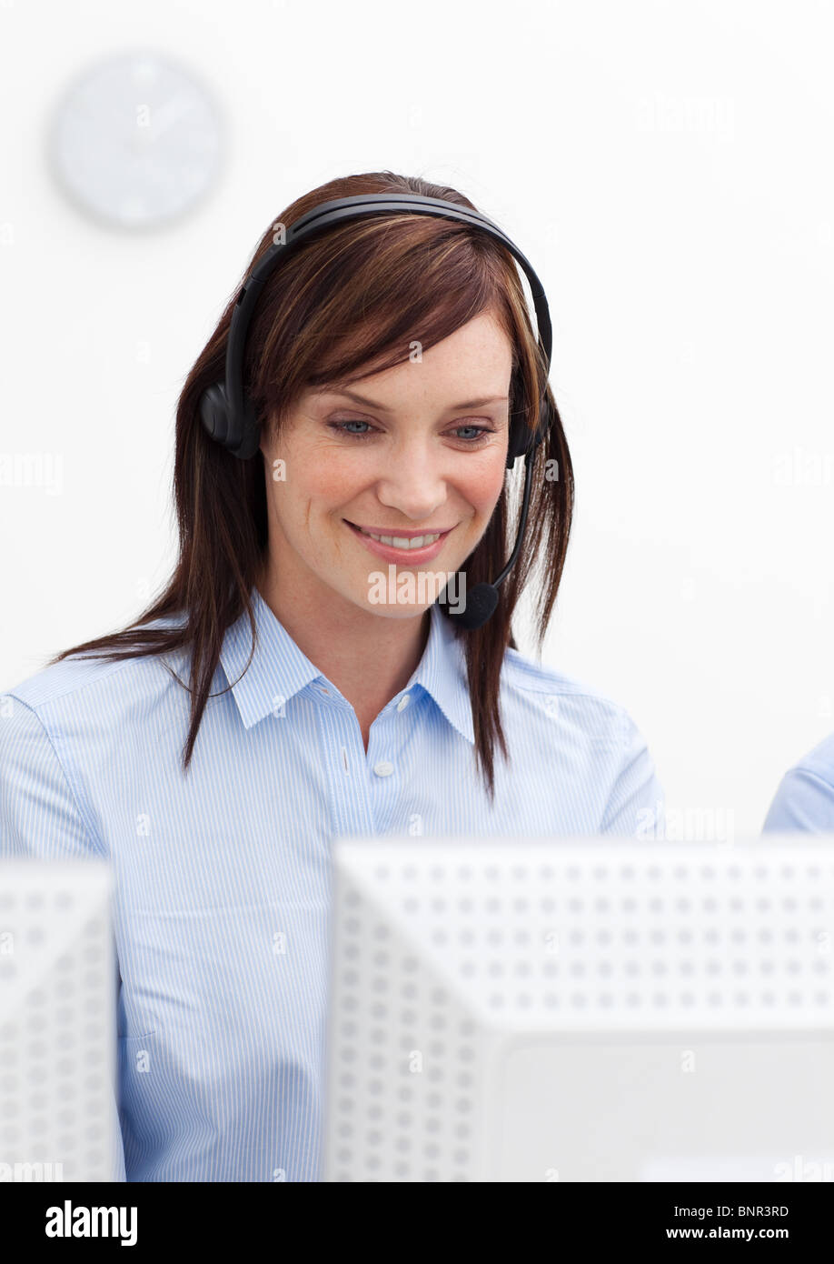 Junge Geschäftsfrau mit Kopfhörer auf in einem Callcenter Stockfoto