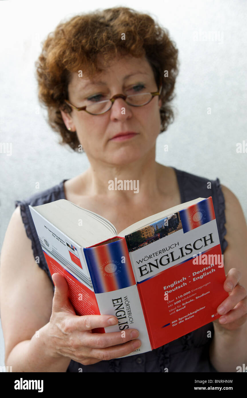 Frau betrachten Deutsch Englisch Wörterbuch von Wörterbuch veröffentlicht Stockfoto