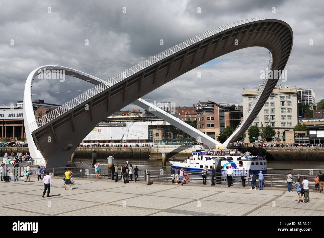 Zuschauer beobachten Sie, wie ein Vergnügensboot, die Fortuna die offene Gateshead Millennium Bridge, England, UK durchläuft Stockfoto