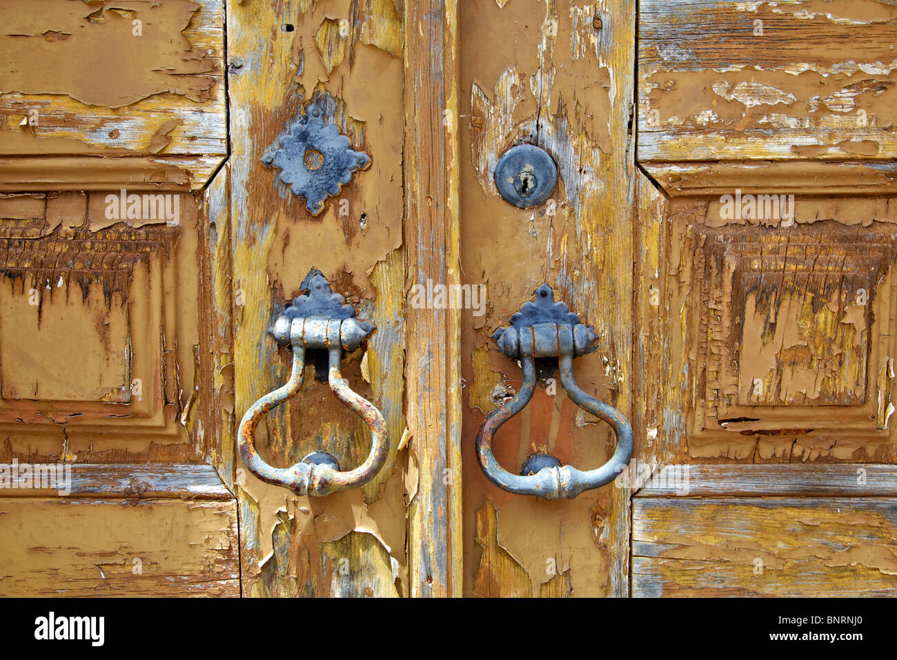 Rustikale verrostete Tür klinkt sich eine Tür mit abblätternde braune Farbe verblasst. In dem mittelalterlichen Dorf Obidos genommen Stockfoto