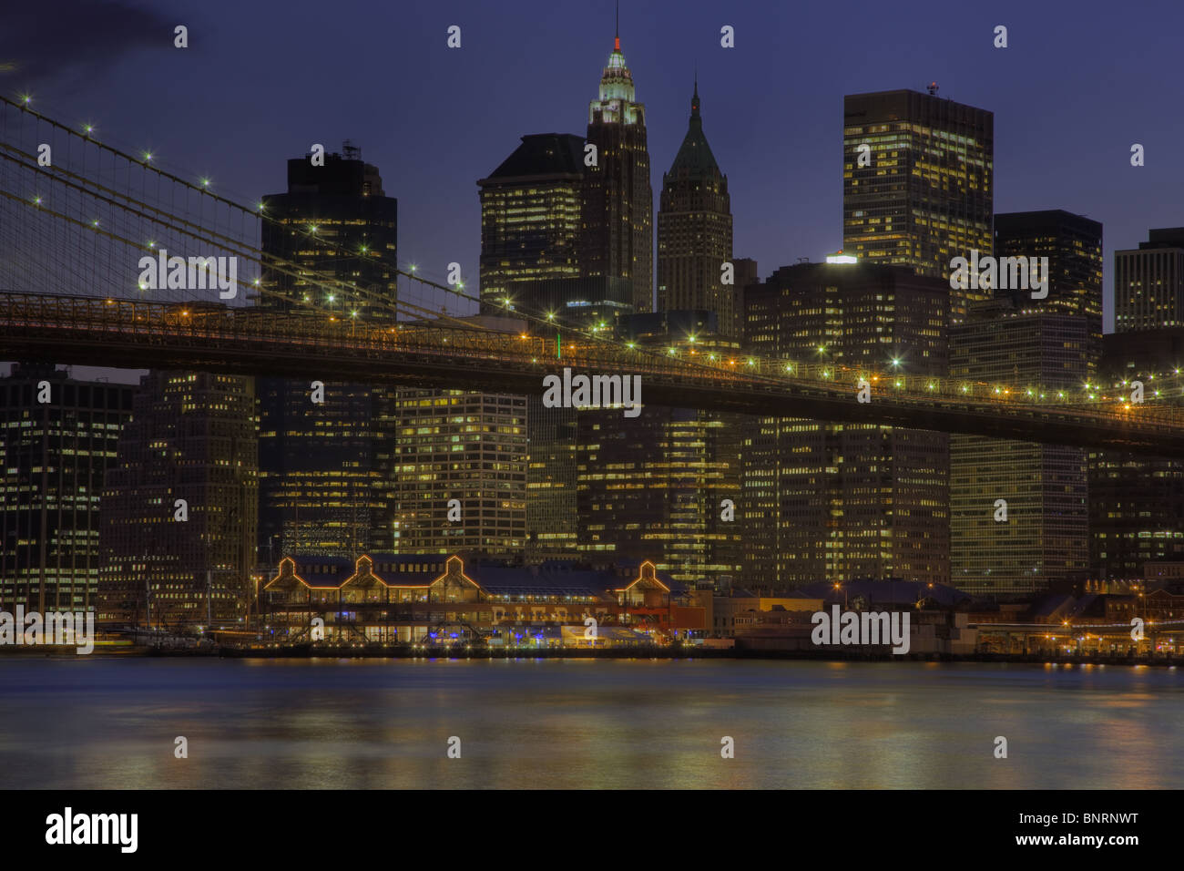 Brooklyn Bridge, East River, South Street Seaport und unteren Skyline von Manhattan in der Dämmerung in New York City. Stockfoto