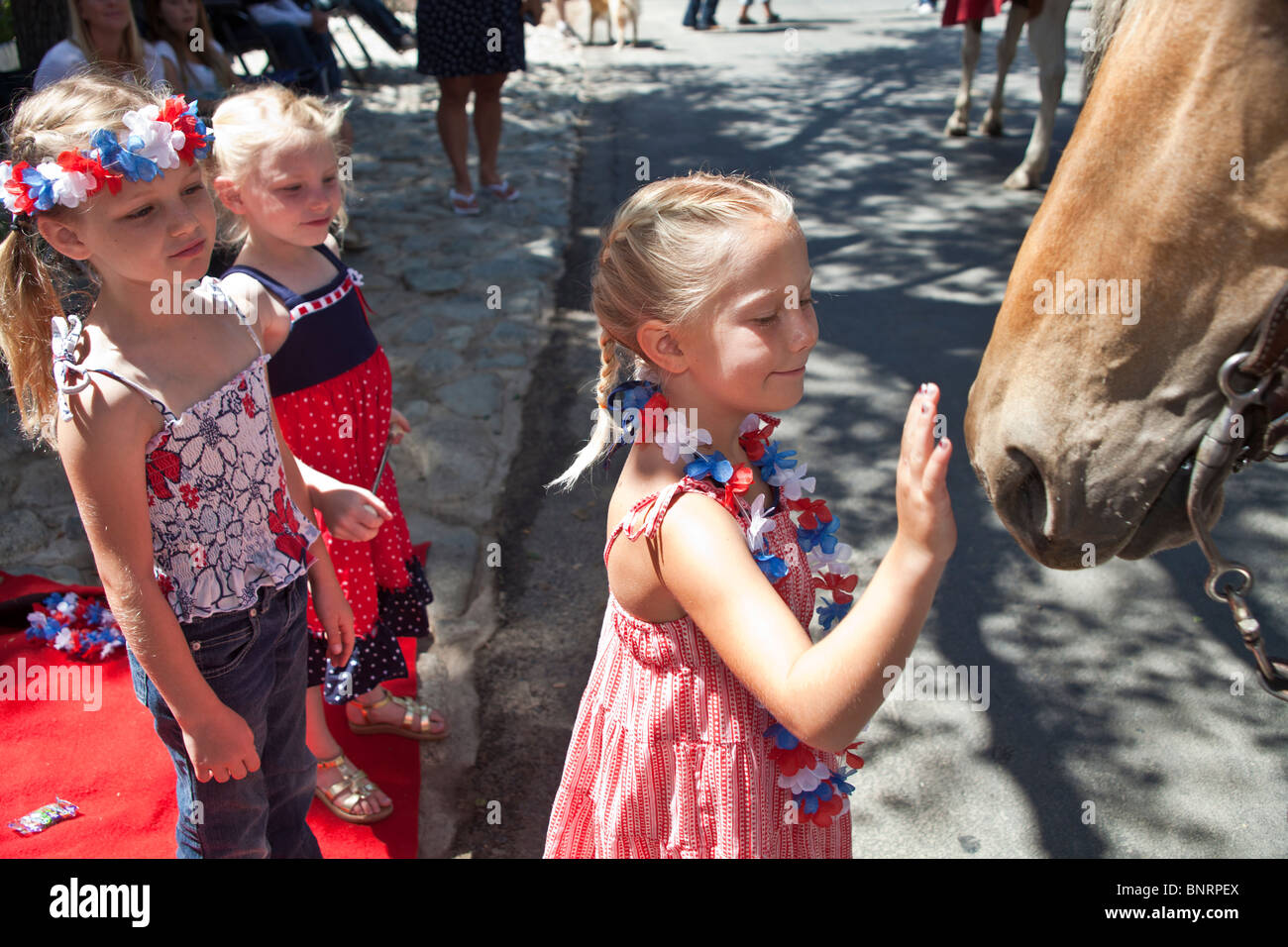 5-6 Jahre altes Mädchen streicheln Pferd im 4. Juli Independence Day Parade. © Myrleen Pearson Stockfoto