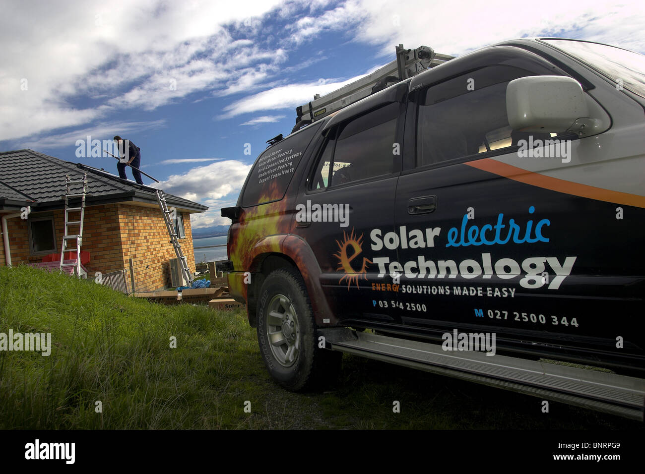 Qualifizierte Handwerker, die Installation von solar-Warmwasser-System zu einem Haus, Nelson, New Zealand, die Stadt mit der höchsten Sonnenscheinstunden Stockfoto