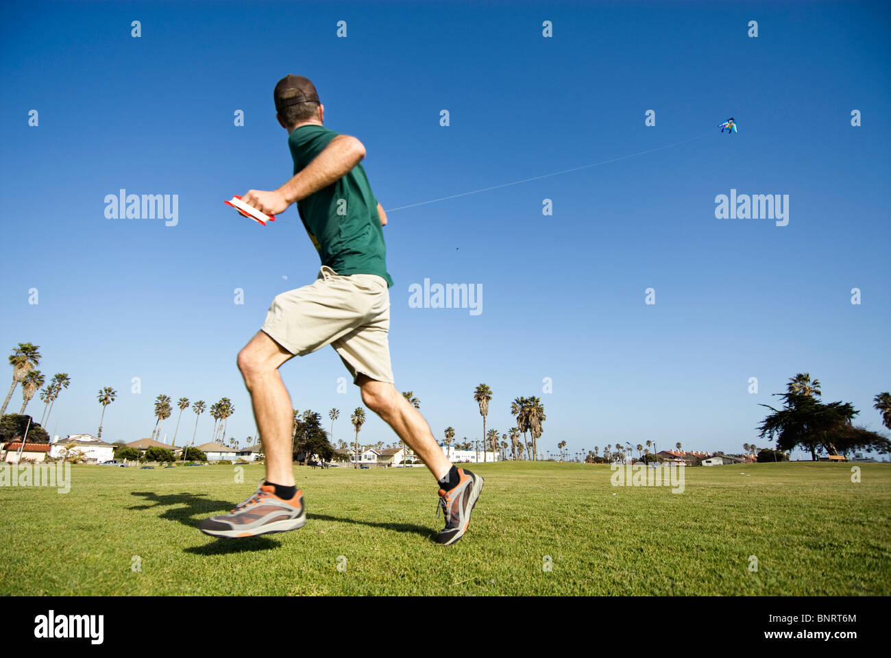 Ein junger Mann fliegt einen Drachen an einem sonnigen Nachmittag California in Ventura, Kalifornien. Stockfoto