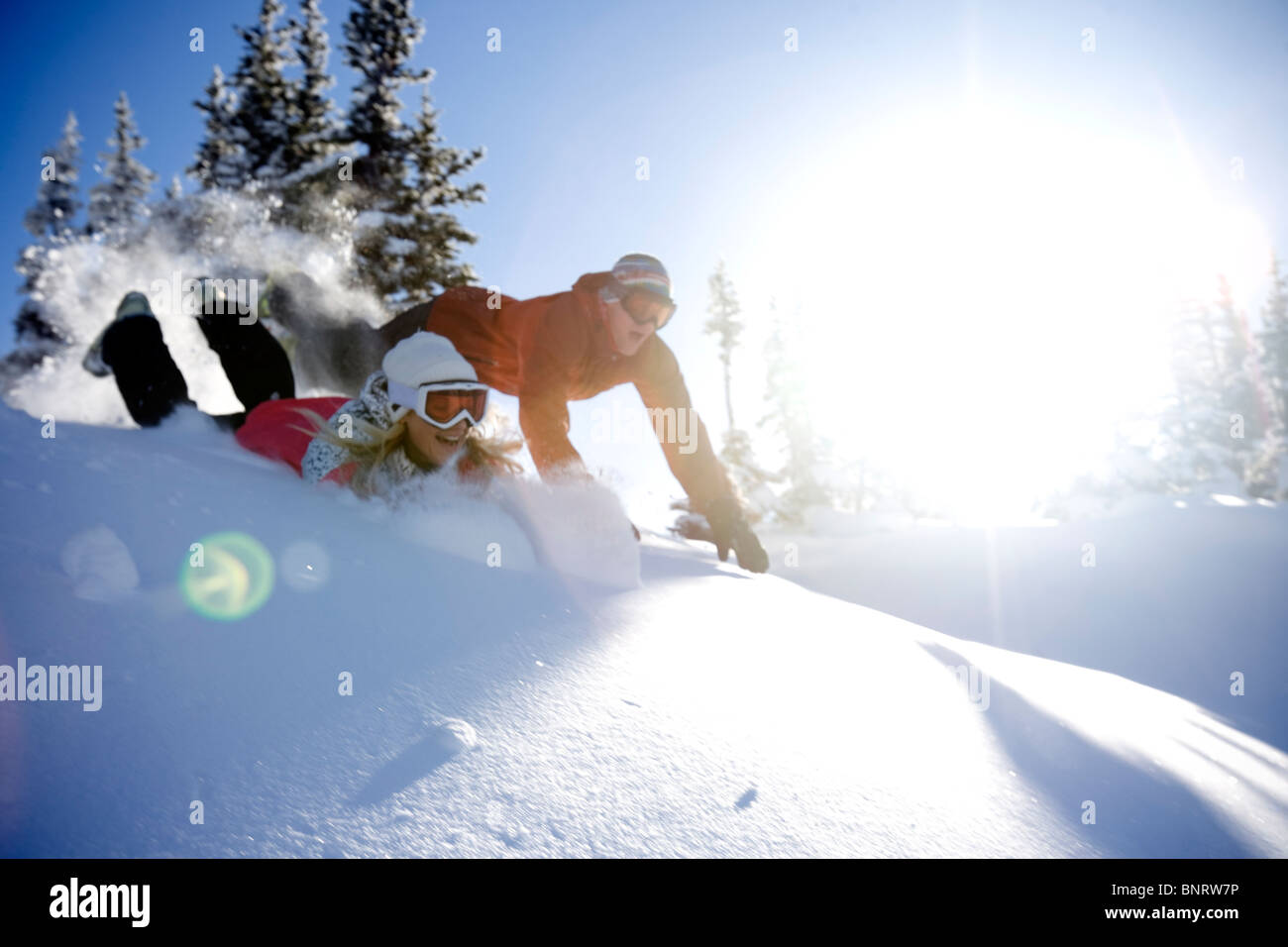 Ein Mann und eine Frau spielen im Schnee in den Bergen. Stockfoto