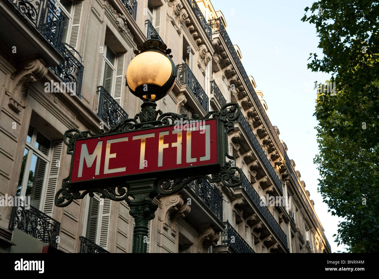 Ikonische Bild von Paris Metro-Zeichens mit dem typischen französischen Gebäude im Hintergrund Stockfoto