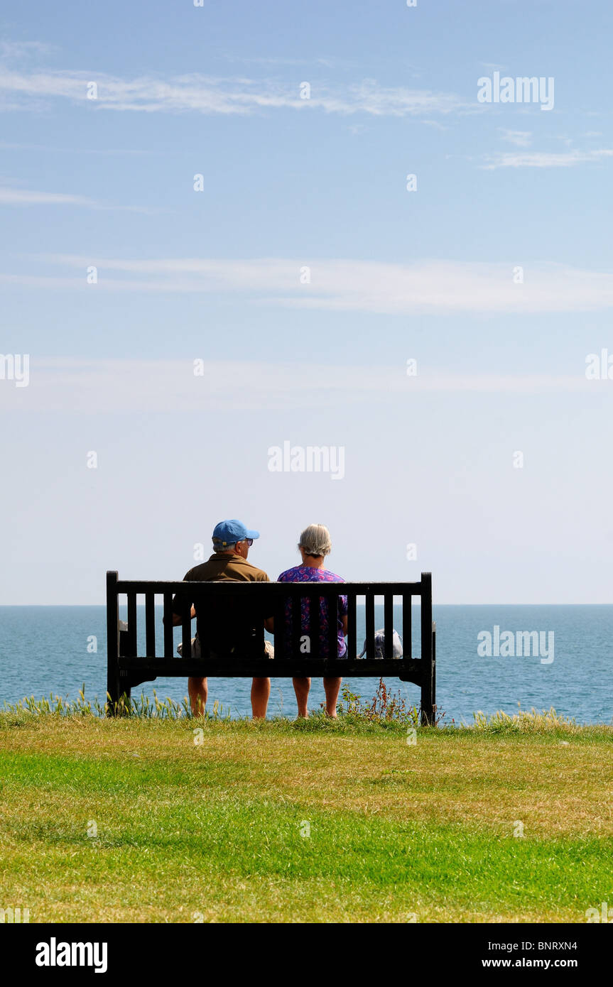 Rückansicht des älteren Ehepaar auf Klippe Bank Blick auf das Meer Stockfoto
