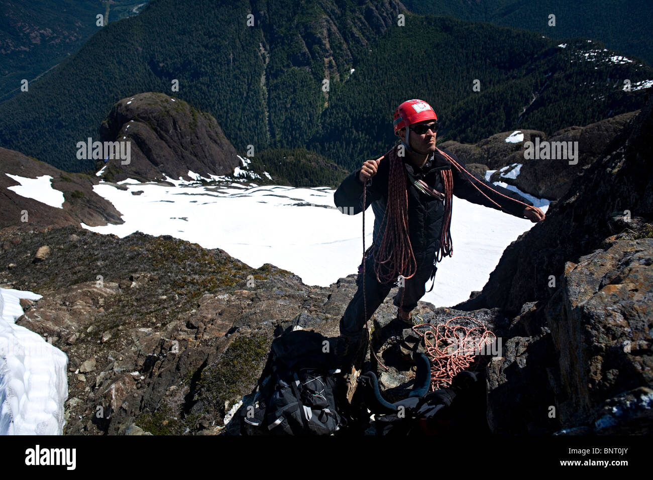 Bergsteiger Spulen ein Kletterseil hoch oben auf einem Bergrücken in den Bergen. Stockfoto