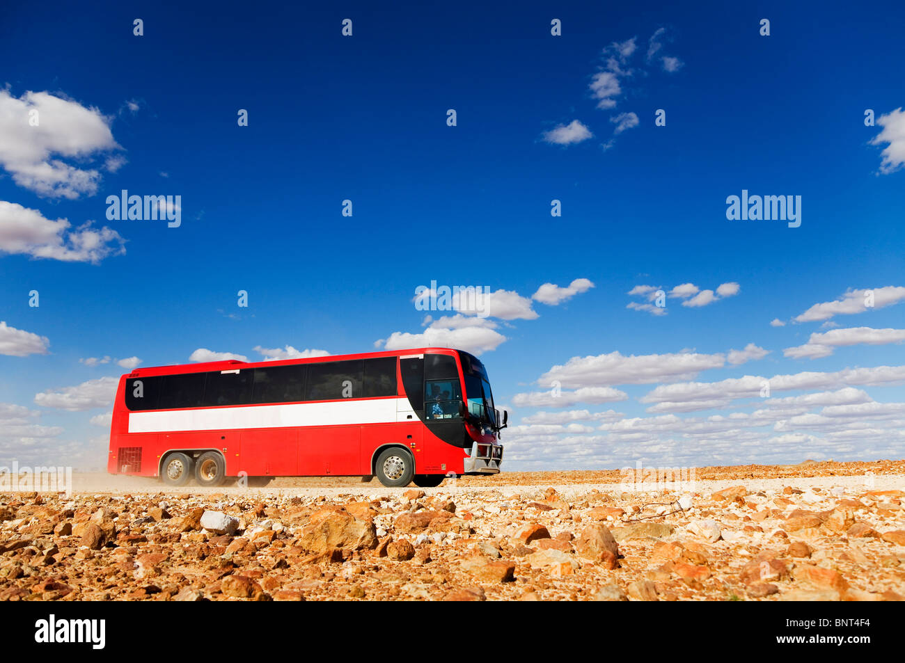 Ein Bus fährt auf einem Schotterweg im Outback von Queensland, in der Nähe von Birdsville, Queensland, Australien. Stockfoto