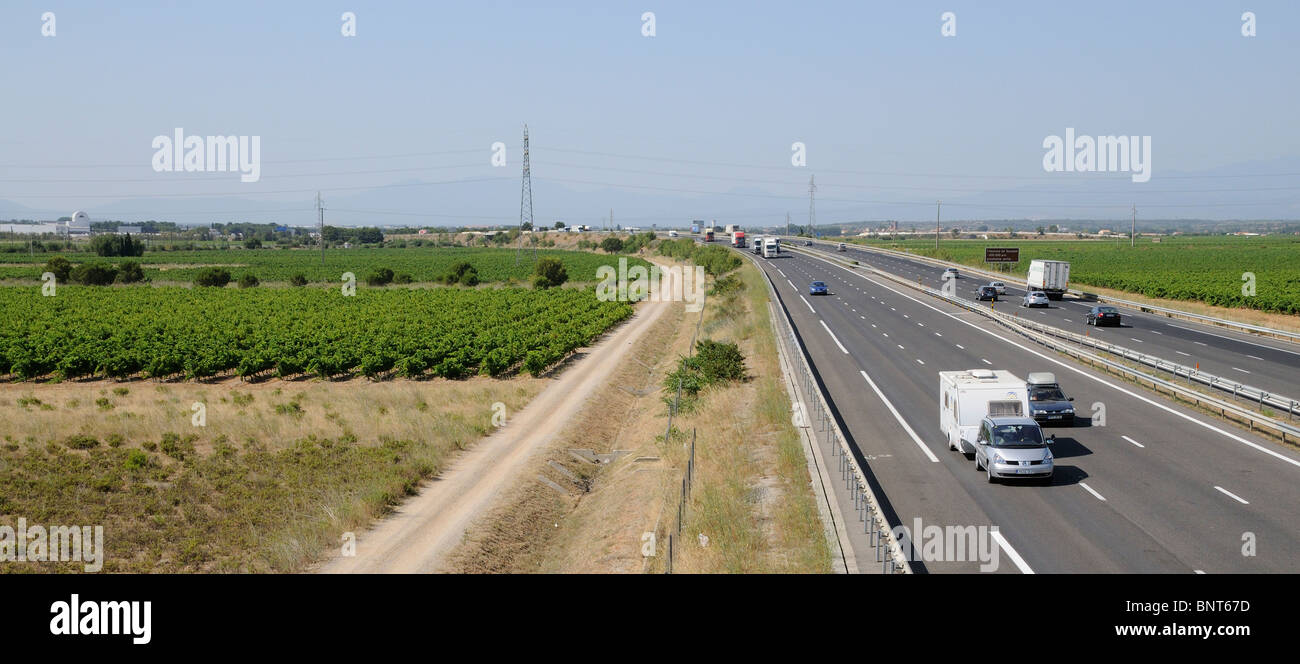A9 Autoroute Fahrbahnen gesehen nördlich von Perpignan südlichen Frankreich Urlaub Verkehr vorbei an Weinbergen auf beiden Seiten der Autobah Stockfoto