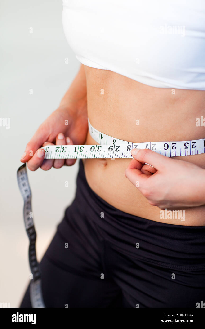 Junge Frau mit einem Maßband messen Stockfoto