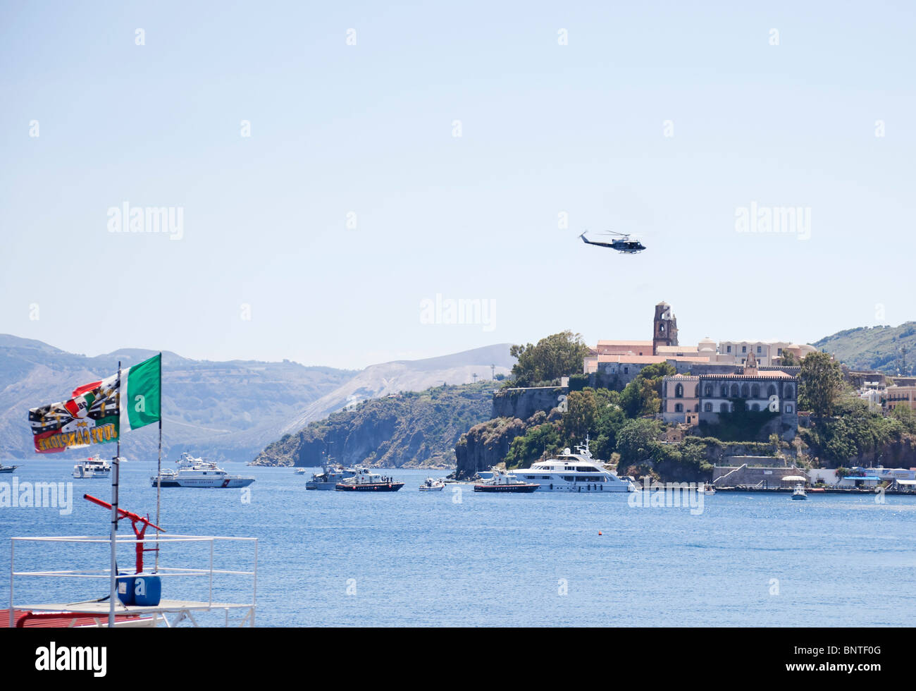 Italienische Polizei eskortiert und hielt eine Superyacht mit einem Hubschrauber und einige Schiffe in Lipari der Äolischen Inseln. Stockfoto