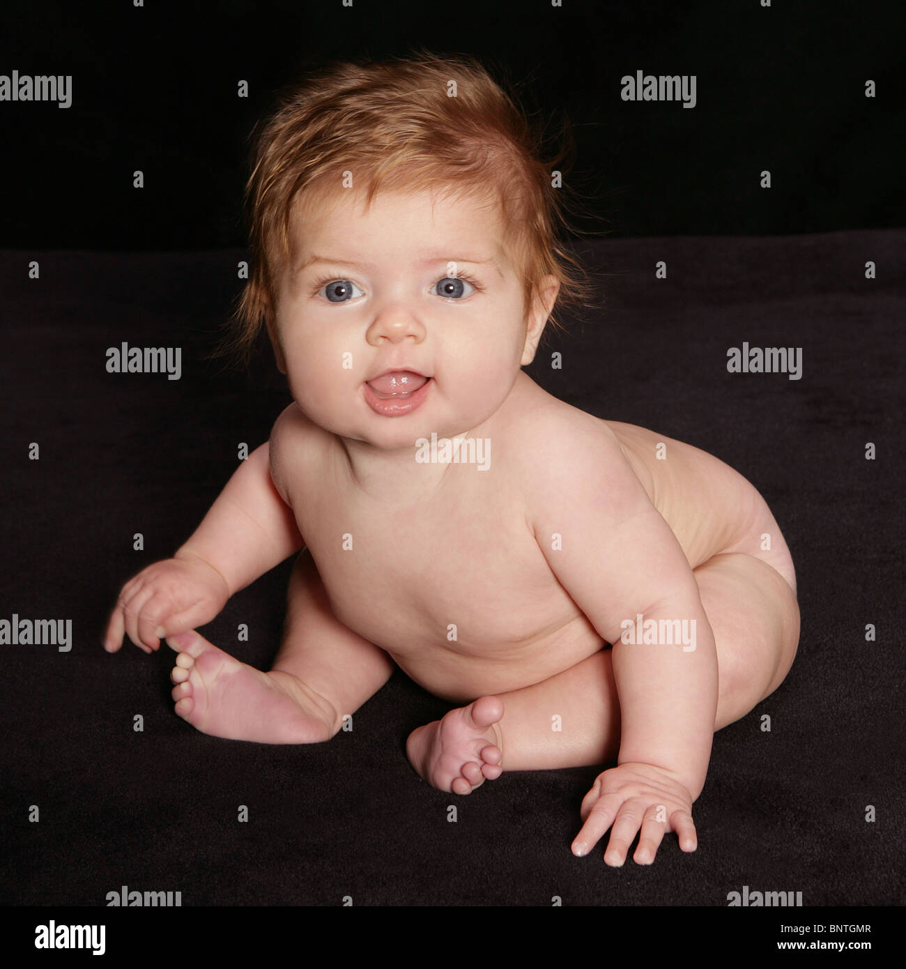 nackte baby sitzen schiefe über Stockfoto
