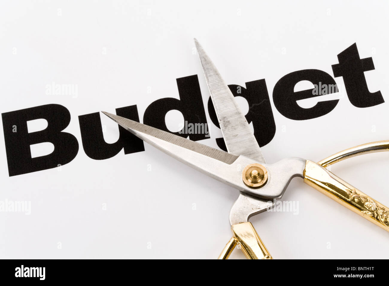 Text von Budget und Scheren, schneiden Konzept des Haushalts Stockfoto