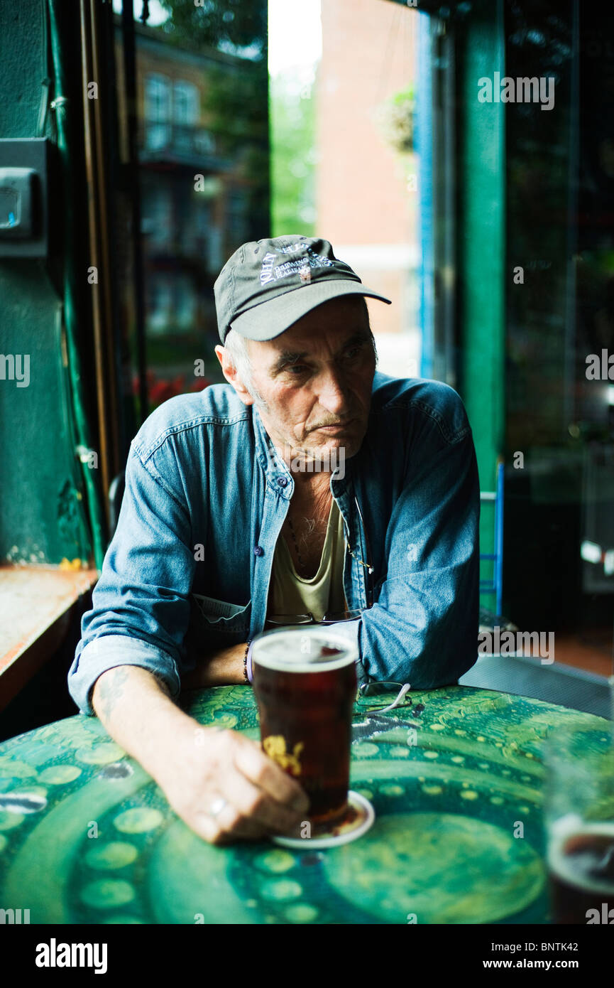 Alter Mann mit Pint Bier am Stehtisch. Stockfoto