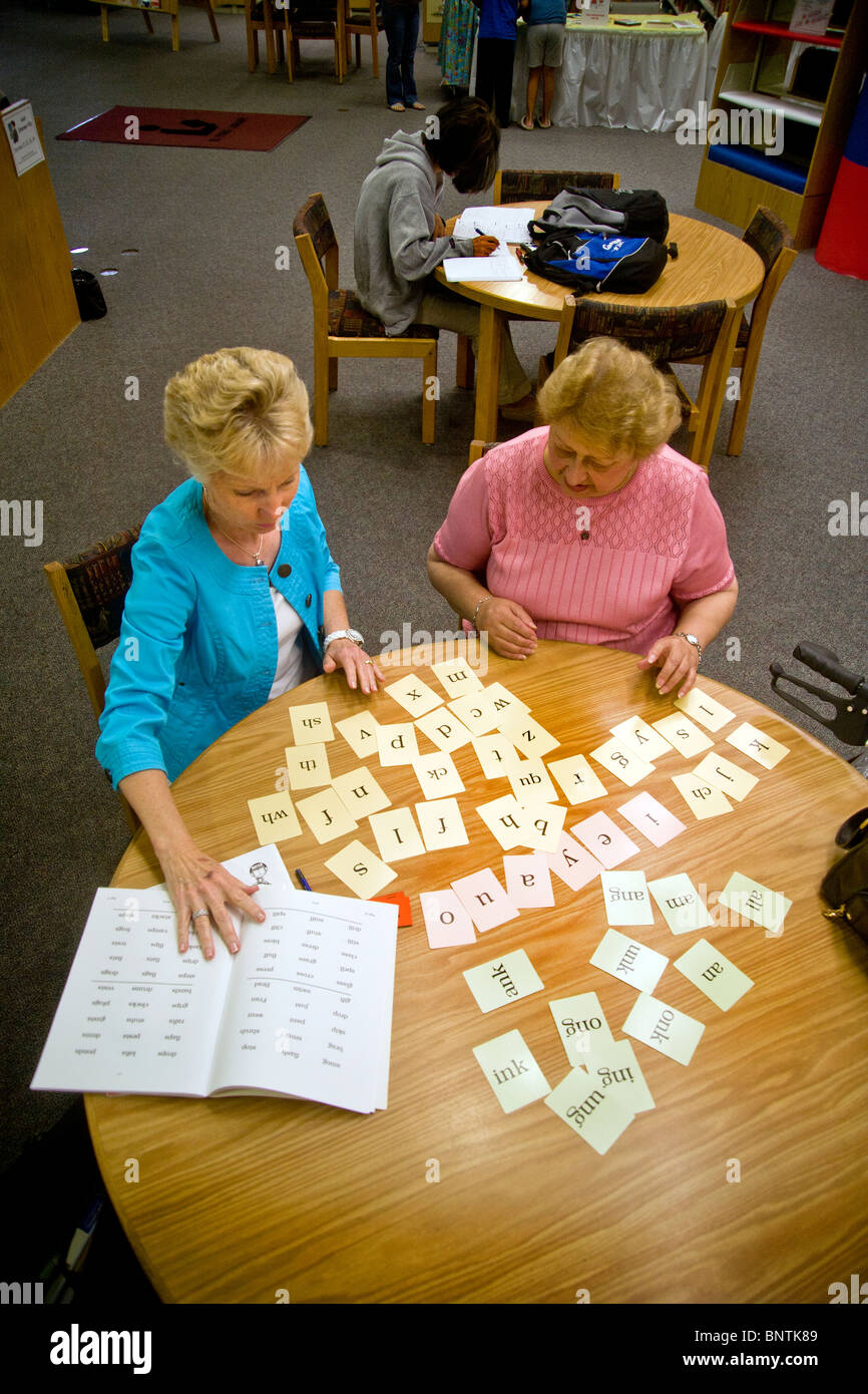 Freiwillige Lesung Lehrer lehrt Lesung für eine ältere Hispanic Frau in öffentlichen Bibliothek in Lake Forest, Kalifornien. VERÖFFENTLICHT Stockfoto