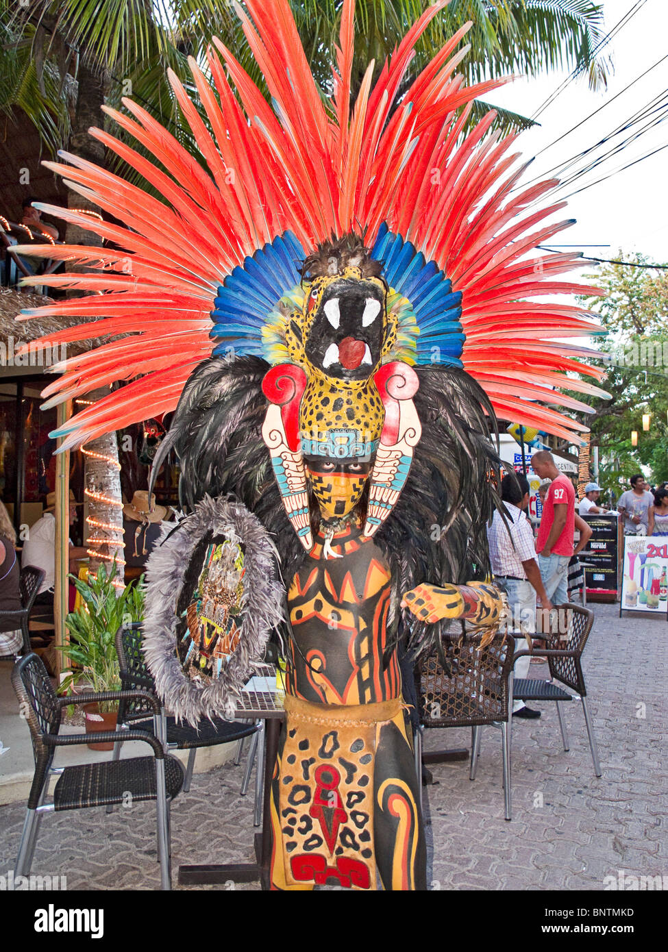 Mann stellt sich als zeremonieller Maya in Tracht auf touristischen Streifen entlang der Fifth Avenue shopping anerkennende, Playa del Carmen, Riviera Maya Stockfoto