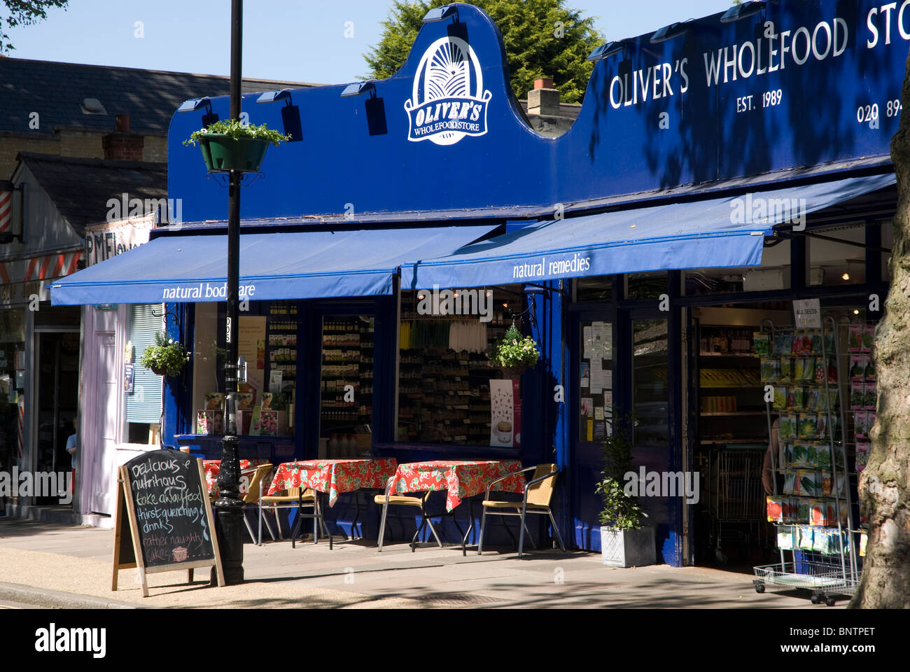 Olivers Vollwert-Shop und ein Café mit Bürgersteig Tische im Kew Dorf Surrey, England UK Stockfoto