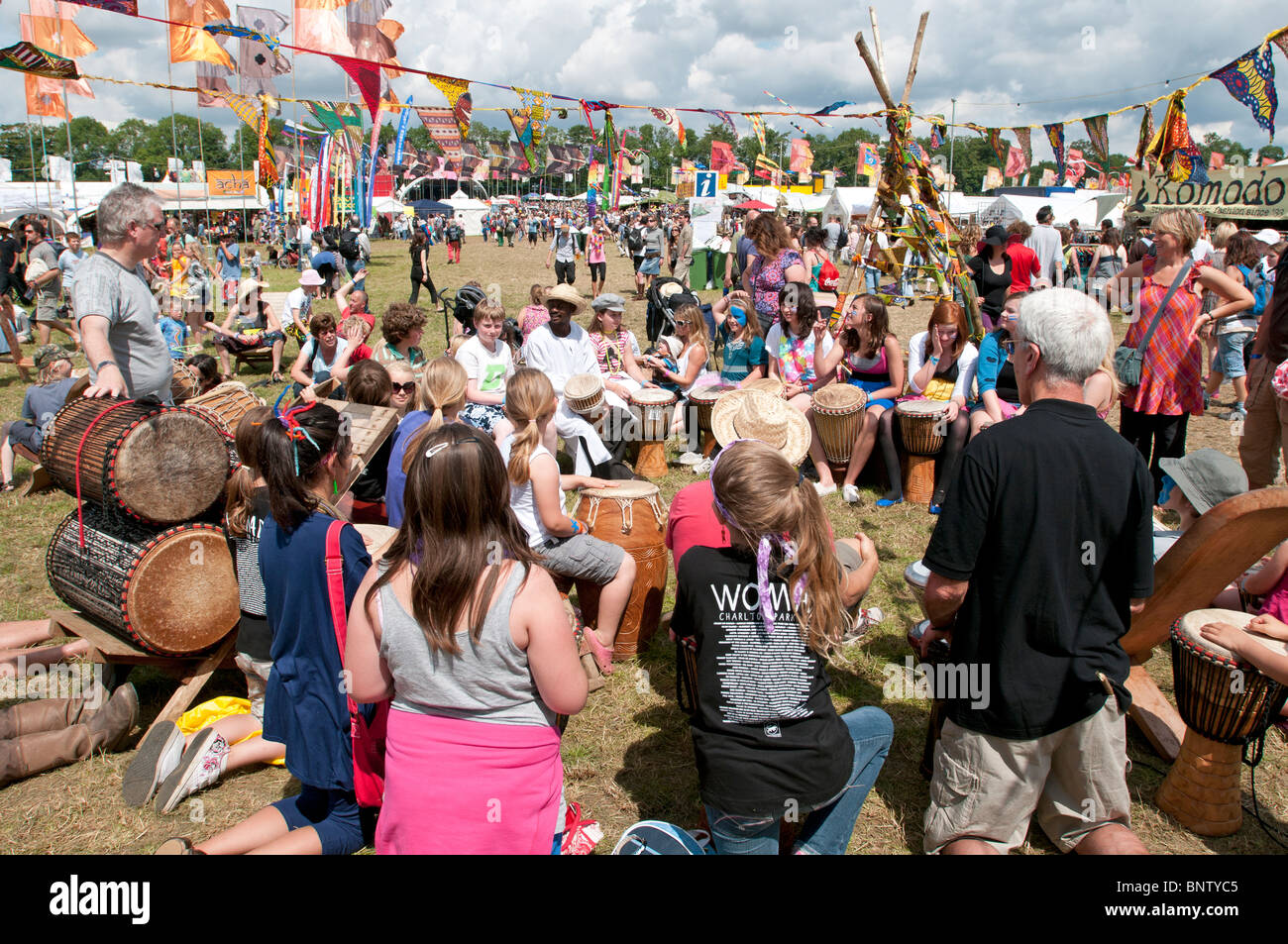 A-Klasse Trommeln statt beim Musikfestival WOMAD Charlton Park Wiltshire UK mit Massen von Festival Familien rund um den Schlagzeuger Stockfoto