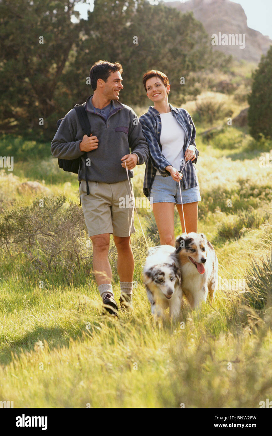 Paare, die ihre Hunde auf dem Land Stockfoto