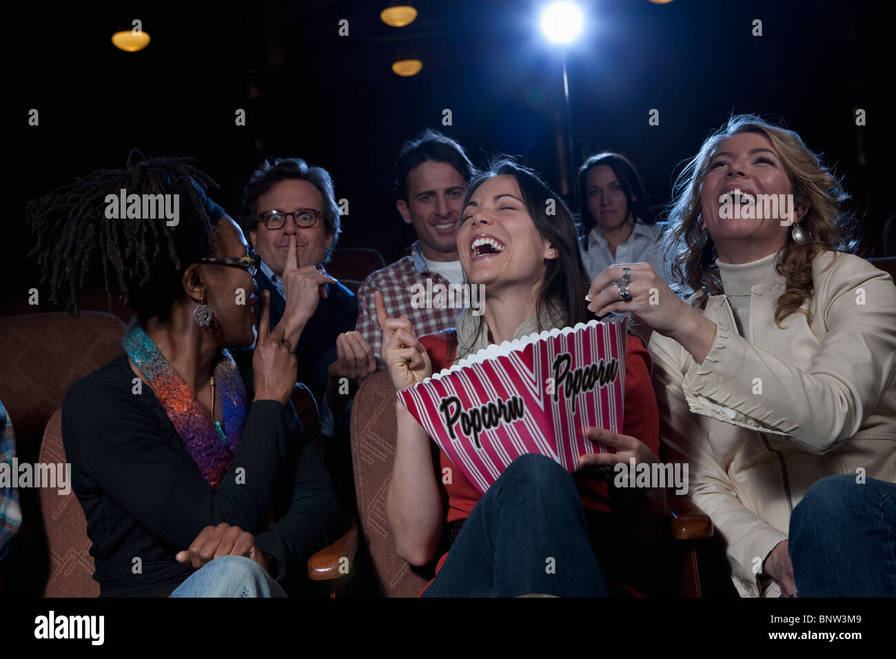 Frauen, die laut lachend in Kino Stockfoto