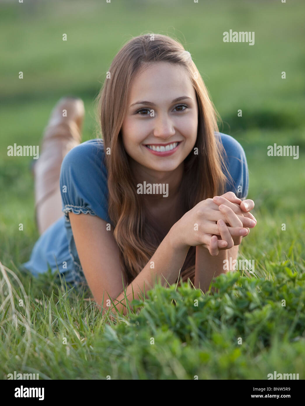 Schöne langhaarige Frau entspannen auf dem Rasen Stockfoto