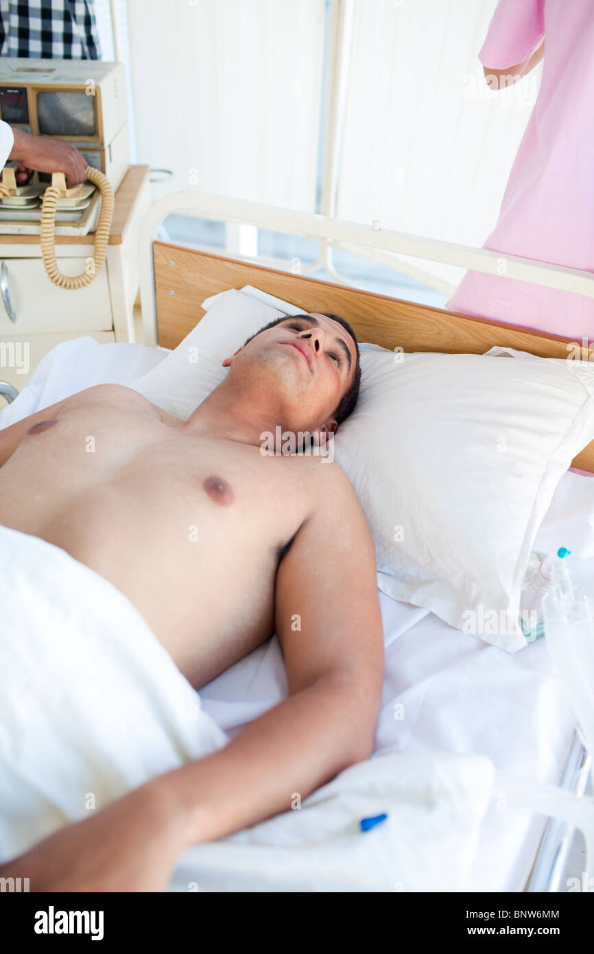 Drilliche Patient liegt in einem Krankenhausbett Stockfoto