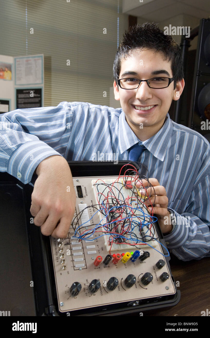 Hispanische männlichen Studenten an der Carver Magnet High protzt Platine, die er entwarf und baute für engineering Klassenprojekt Stockfoto