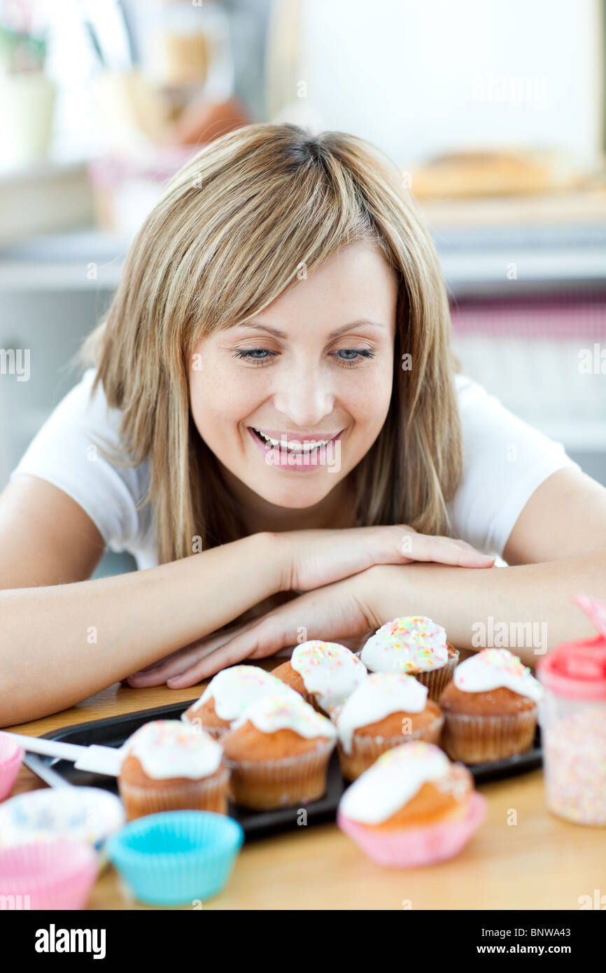 Stets gut gelaunte Frau Blick auf Kuchen in der Küche Stockfoto